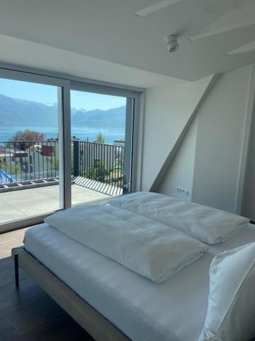 a bed in a bedroom with a large window at Das Anton in Gmunden