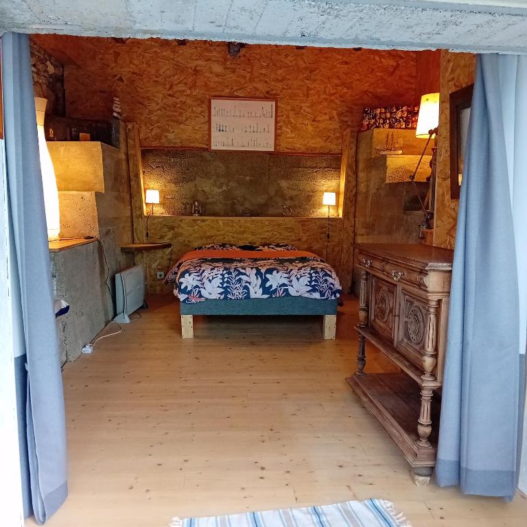 une chambre avec un lit et une table en bois dans l'établissement Mas Dupoune avec Piscine & Spa, à Sumène