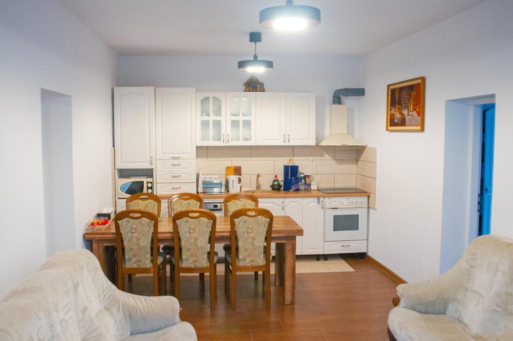 a kitchen with a table and chairs in a room at Cazare La Cetate in Moşna