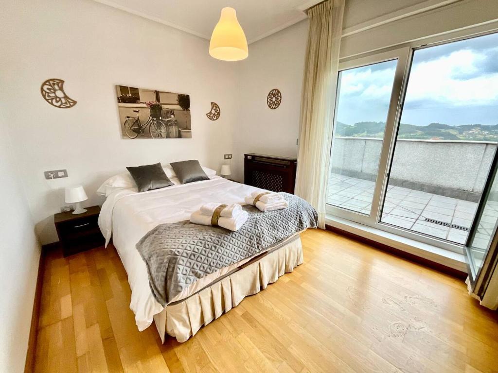 een slaapkamer met een groot bed en een groot raam bij La Terraza del Valle Pravia in Pravia