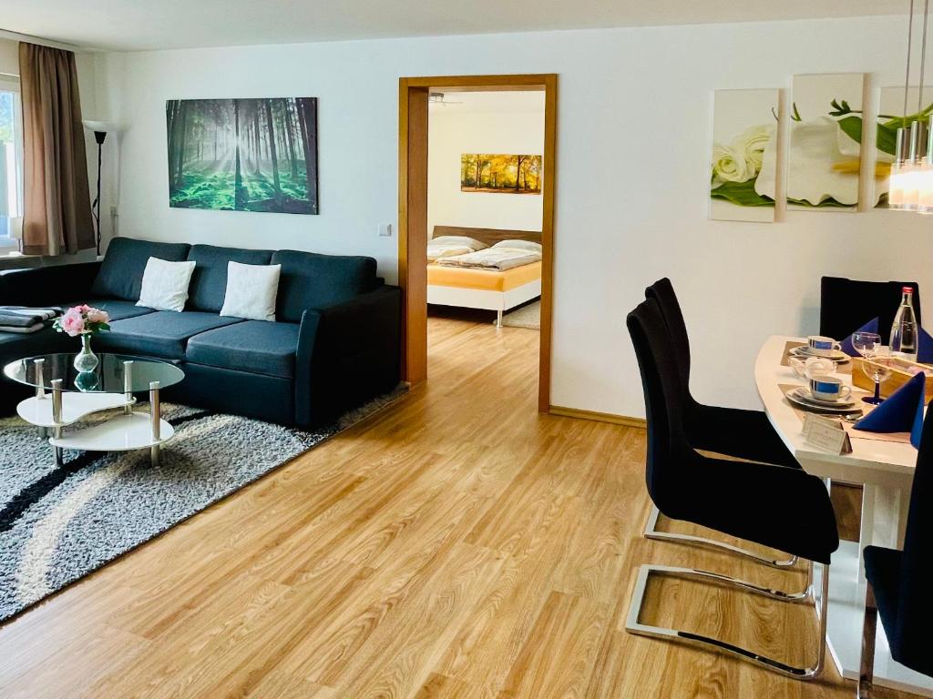ein Wohnzimmer mit einem blauen Sofa und einem Tisch in der Unterkunft Haus Jenni im Schwarzwald, 3,5-Zimmer, große Terrasse in Freudenstadt