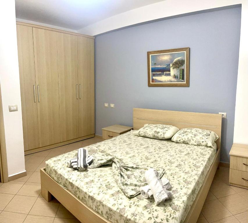 a bedroom with a bed with a phone on it at Beach Apartments Durres in Durrës