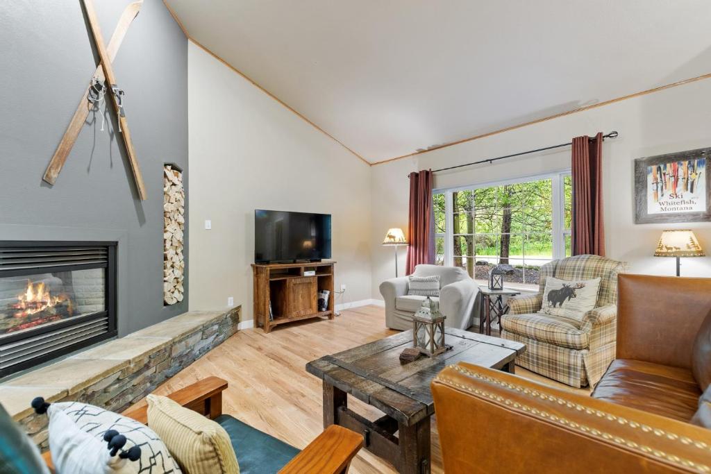 a living room with a fireplace and a tv at Suncrest Hideaway in Whitefish