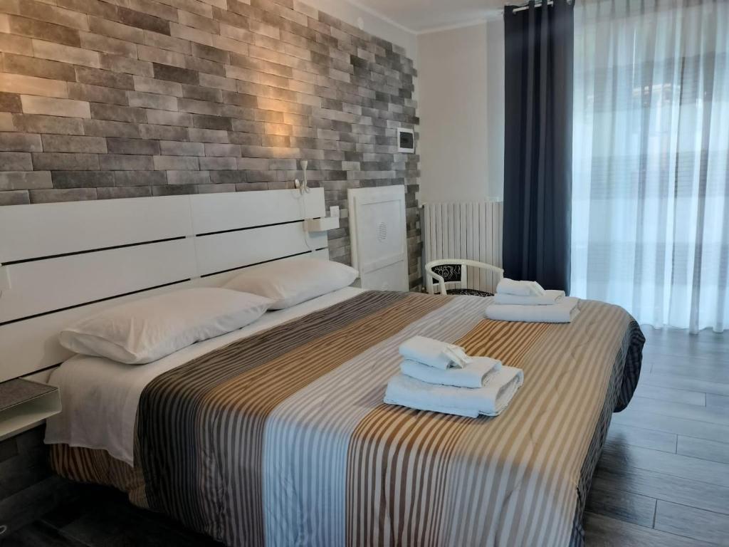 a bedroom with a large bed with towels on it at La casa di Ali in Torre Maggiore