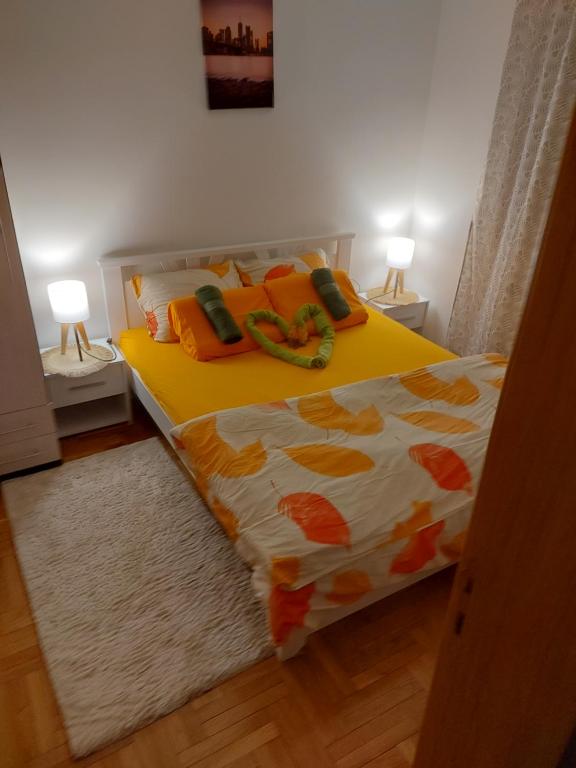 uma cama amarela num quarto com duas lâmpadas em Stancicmilena em Pozarevac