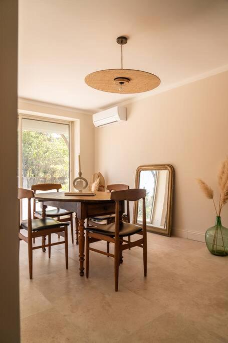 a dining room with a table and chairs and a mirror at Appartement dans maison de campagne lumineuse in Orange
