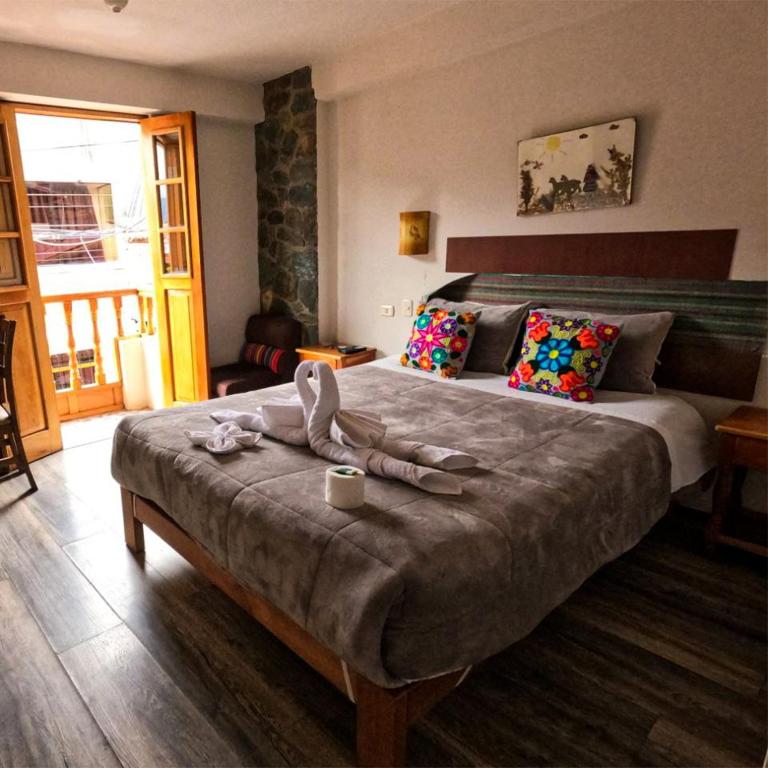 a bedroom with a large bed with towels on it at hostal Balcon de Piedra in Urubamba
