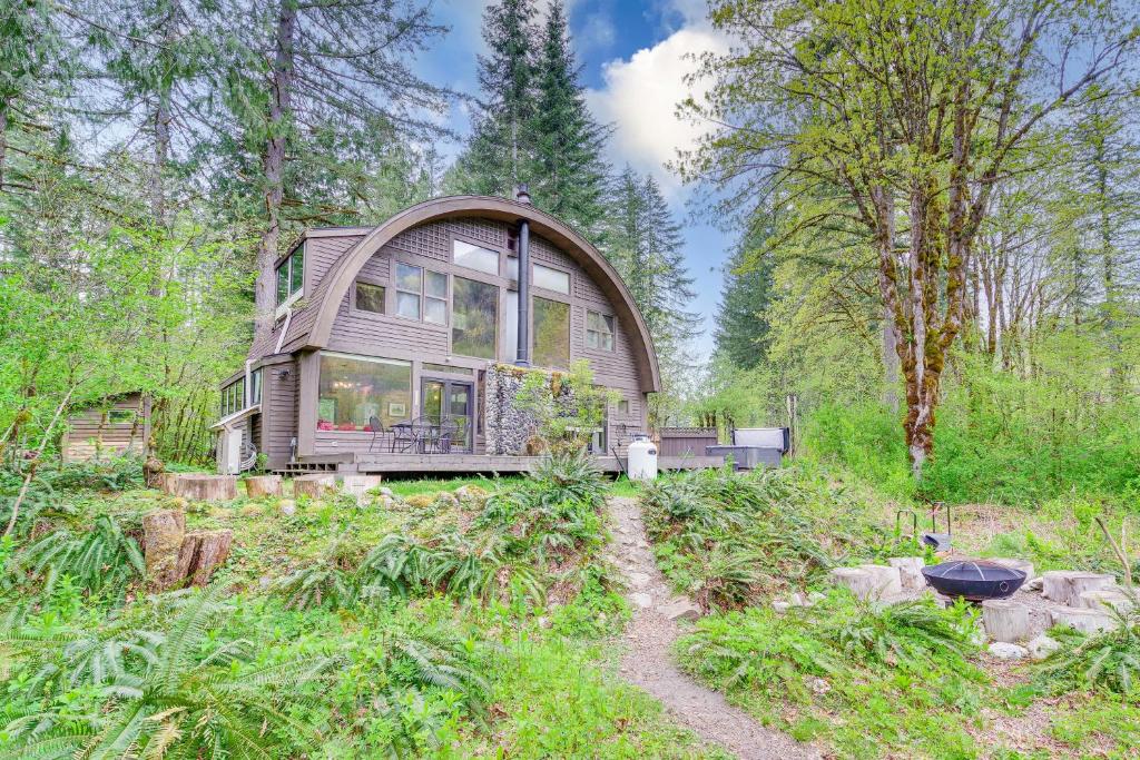 una casa grande en medio de un bosque en Riverfront Skykomish Cabin with Private Hot Tub!, en Skykomish