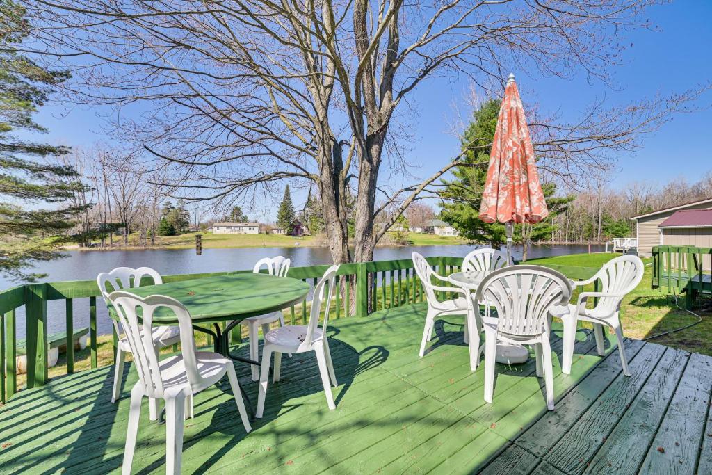 um deque com uma mesa, cadeiras e uma árvore em Peaceful Lakefront Home with Deck in West Branch! em West Branch