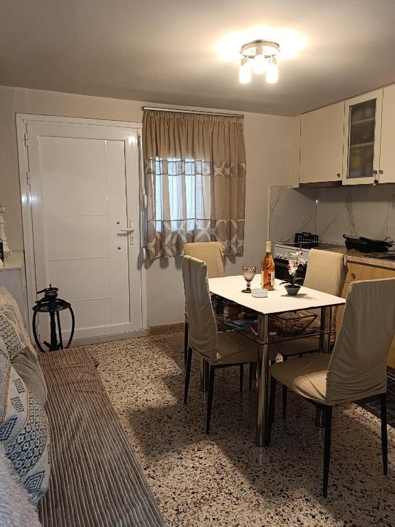 eine Küche und ein Esszimmer mit einem Tisch und Stühlen in der Unterkunft Marina's Seacret Apartment in Korinthos