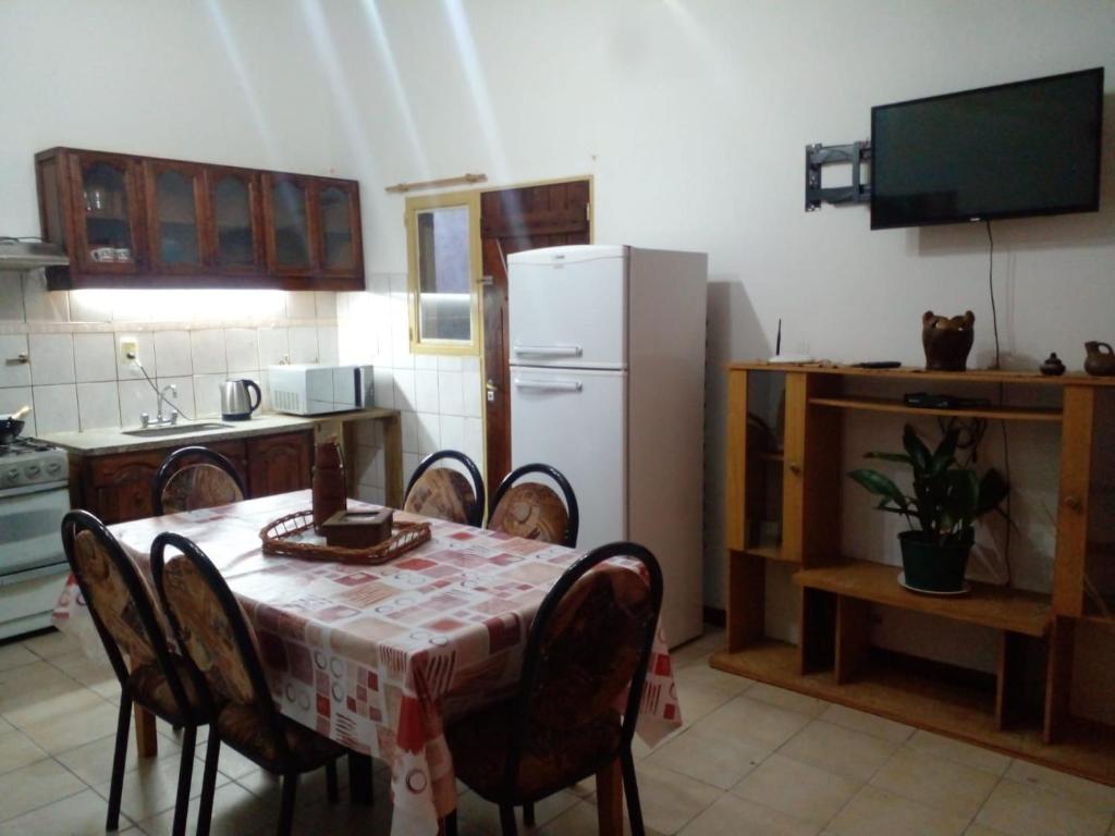 a kitchen with a table with chairs and a white refrigerator at La Soñada in Malargüe