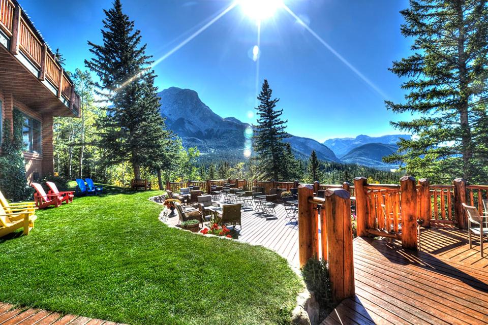 a backyard with a deck with a view of mountains at Overlander Mountain Lodge in Jasper