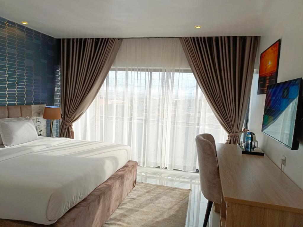 ein Hotelzimmer mit einem Bett und einem großen Fenster in der Unterkunft Kakanfo Inn & Conference Centre in Ibadan