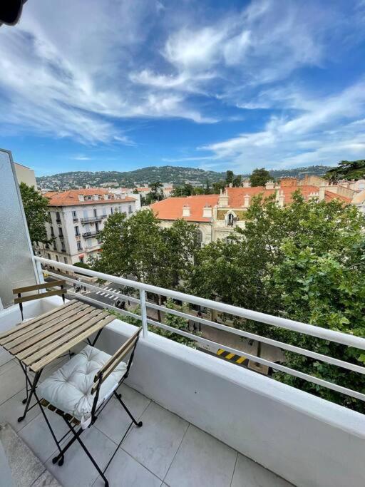 d'un balcon avec un banc en bois et une vue sur la ville. dans l'établissement Joli T2 cannes / croisette, à Cannes