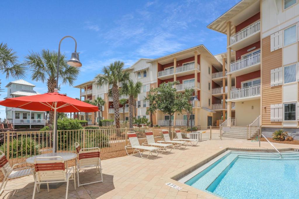 a patio with a table and chairs and a swimming pool at Waterside Village Condo 302 in Mexico Beach
