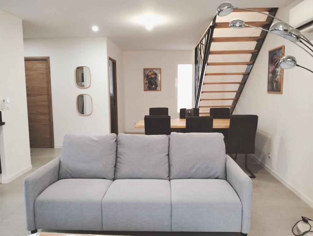 un salon avec un canapé et un escalier dans l'établissement Maison l'Angelina, à Pinet