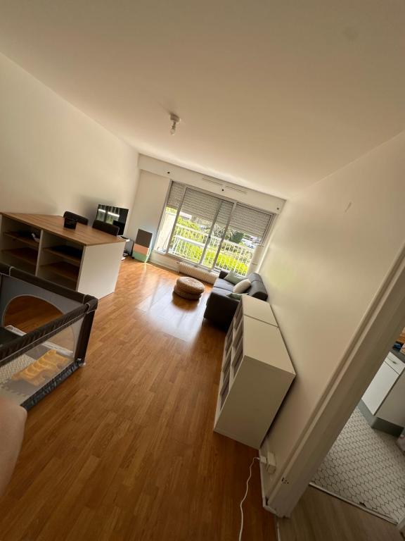 un salon vide avec une grande fenêtre dans l'établissement Cosy flat all confort Puteaux, à Puteaux