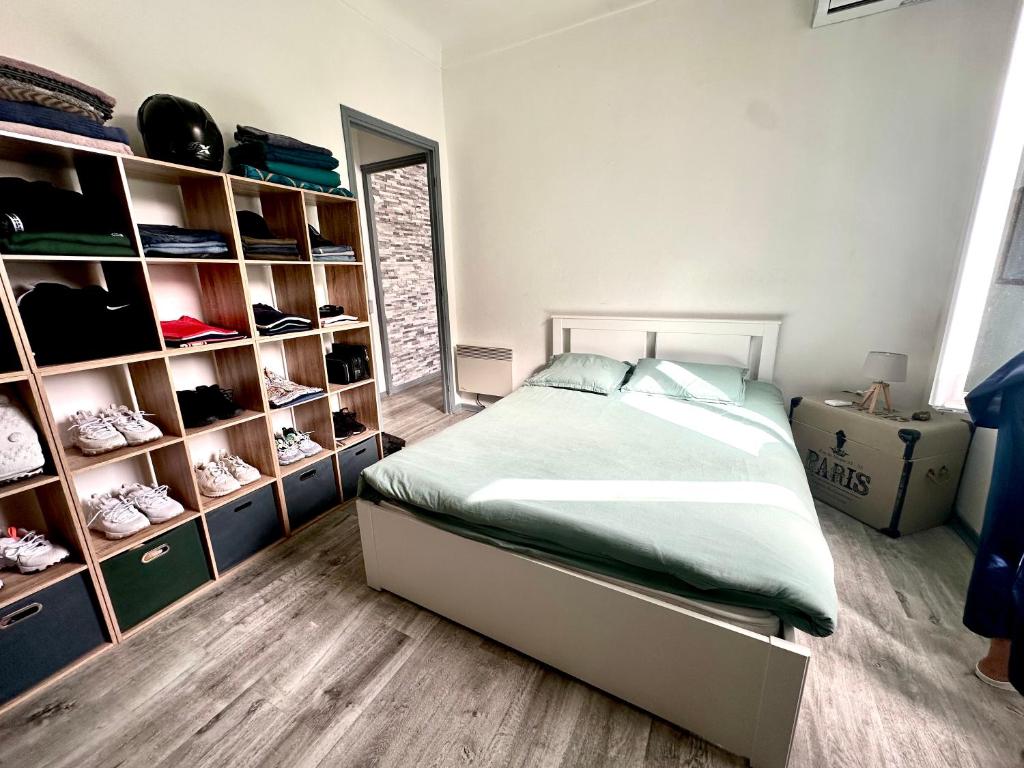 a bedroom with a bed and shelves with shoes at 2pieces au calme avec parking, proche centre et plage in Beaulieu-sur-Mer