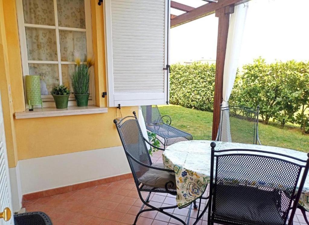 een patio met een tafel en stoelen op een veranda bij Apartment Dragonfly - garden and pool in Manerba del Garda