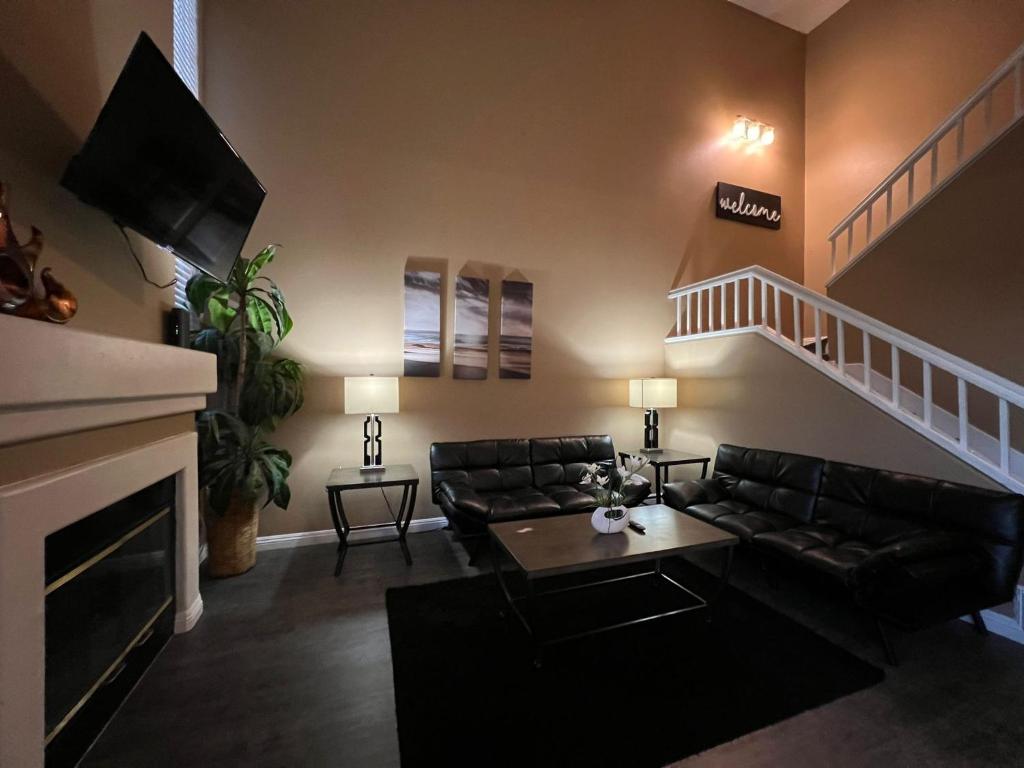 uma sala de estar com um sofá e uma escada em 3 bedroom modern home with pool area at the Tustin Marketplace -15 minutes to Disneyland em Tustin