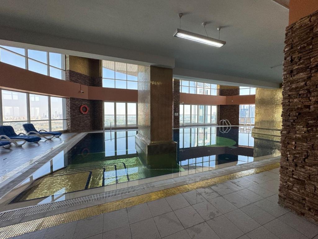 uma grande piscina interior num edifício com janelas em 2 Single Bed Fully Furnished Bed Room Front of Dubai Museum - Trade Center em Dubai