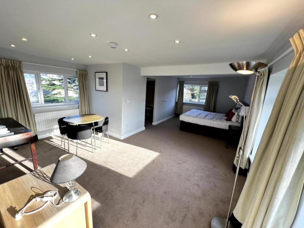 een slaapkamer met een bed en een tafel en stoelen bij The Springfield Hotel in Fairbourne