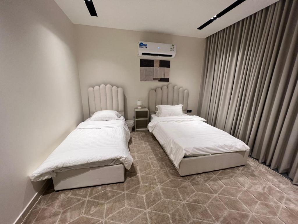 - 2 lits dans une petite chambre avec des draps blancs dans l'établissement Luxury furnished apartment شقة فاخرة الخبر-الحمراء, à Khobar