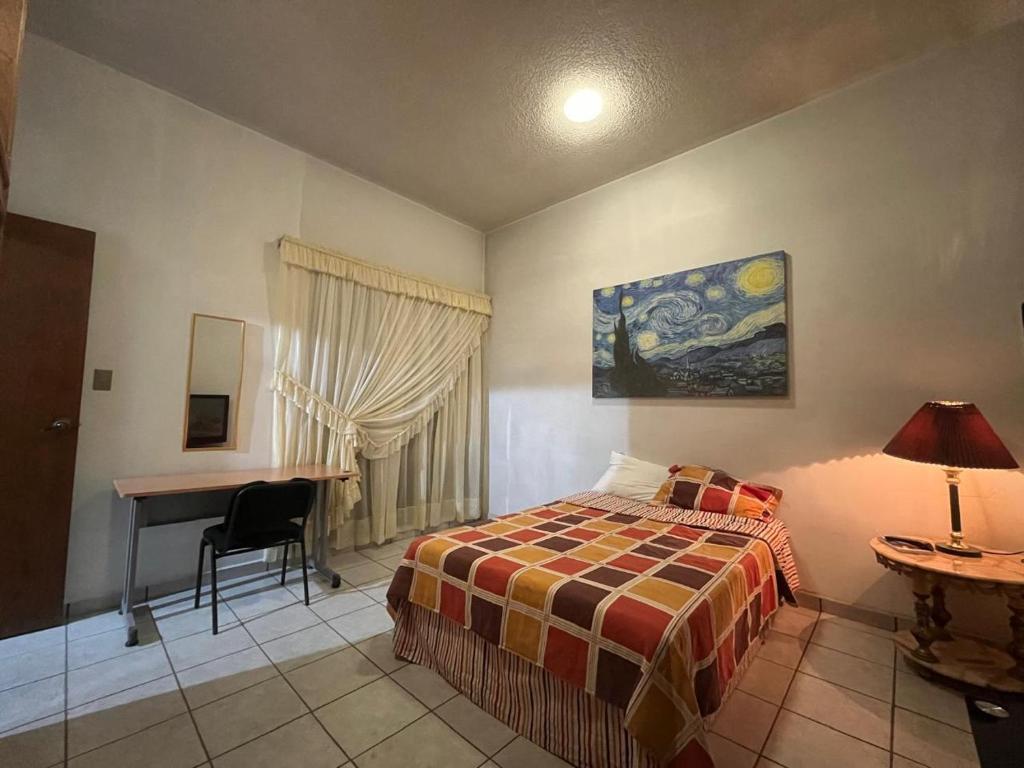 - une chambre avec un lit et un bureau dans l'établissement Misión Vizcaya Hospedaje, à Durango