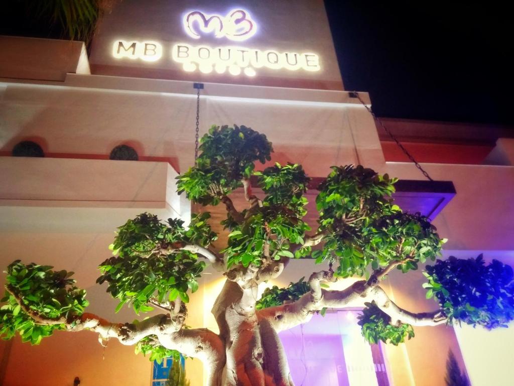a tree in front of a building with a no boutique sign at MB Boutique Hotel - Adults Recommended in Nerja