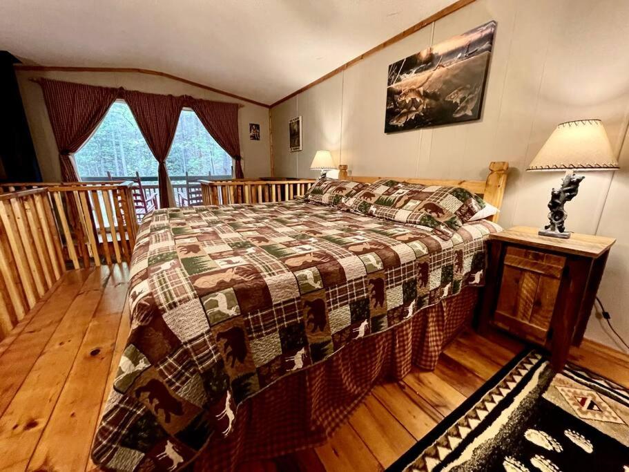 a bedroom with a bed and a wooden floor at Cute Cabin creek & Firepit #12 in Helen