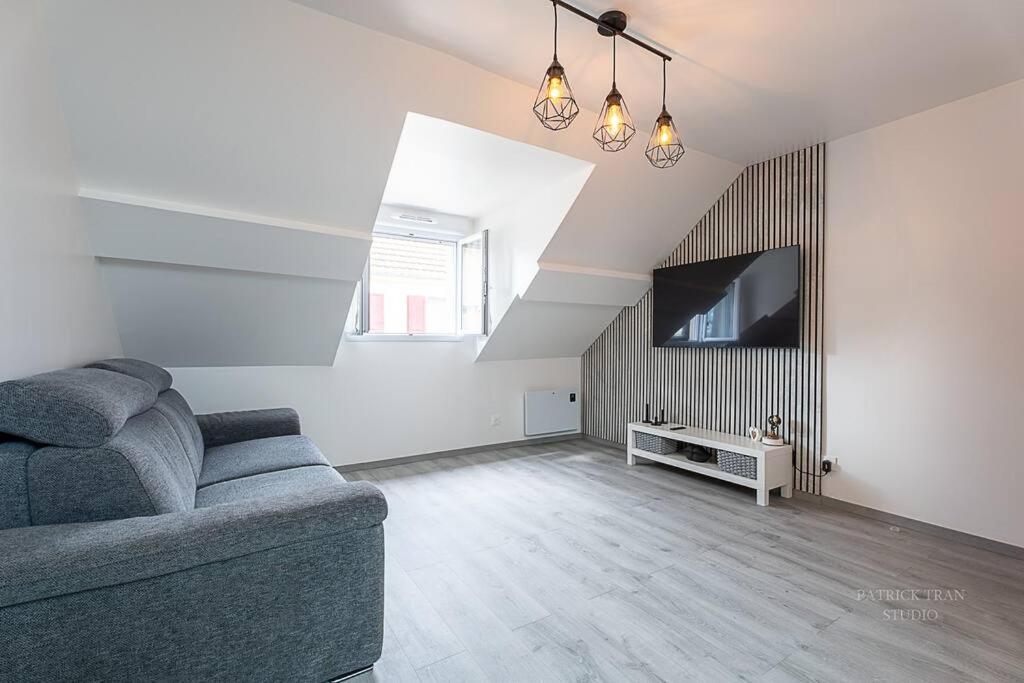 a living room with a couch and a tv at Logement 7 personnes près de Disney & Paris in Chanteloup-en-Brie