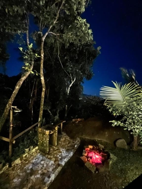 eine Feuerstelle in einem Garten in der Nacht in der Unterkunft Hospedagem Casa Maracujá in Trindade