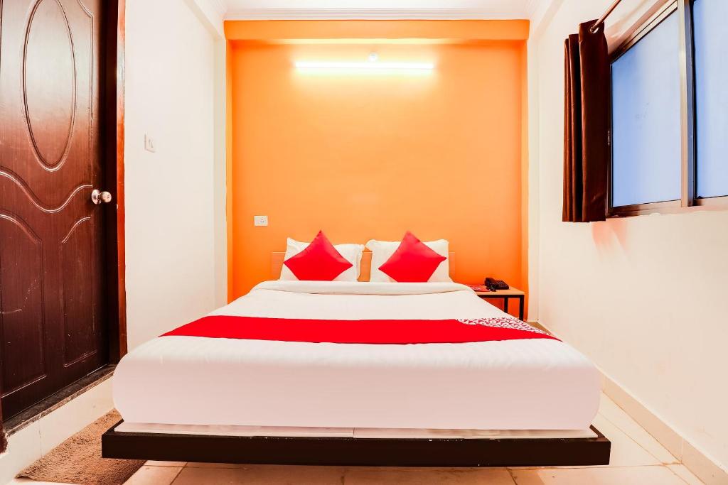 1 dormitorio con 1 cama grande con almohadas rojas en Shri Ganpati Palace, en Chinhat