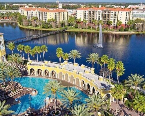 un pont sur une rivière avec des palmiers et des bâtiments dans l'établissement Hilton Grand Vacation Club Tuscany Village, à Orlando