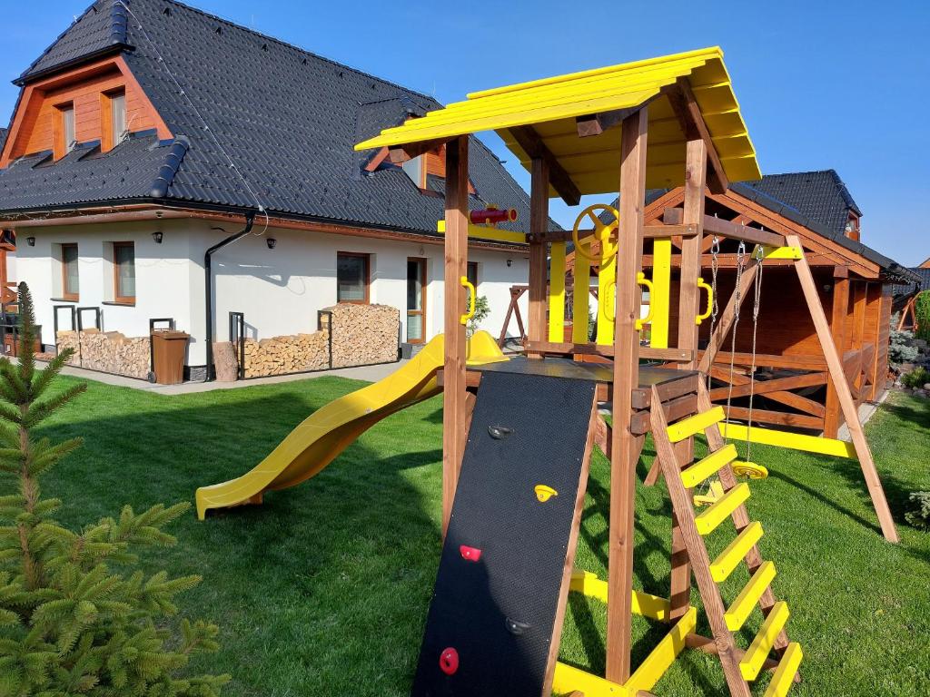 a playground in a yard with a slide at Holiday House Sabala 3 in Stará Lesná