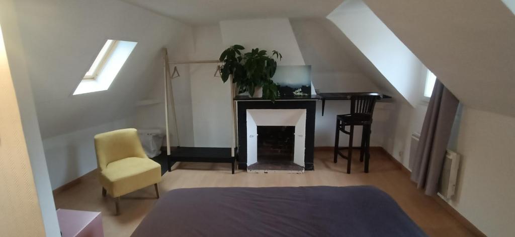 a living room with a fireplace and a table and chair at Maison + parking. Calme, confort in Rouen