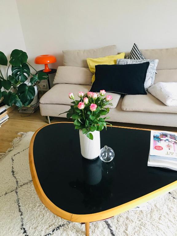 - un salon avec une table basse et des fleurs dans l'établissement Appartement rosaluz, à Montpellier
