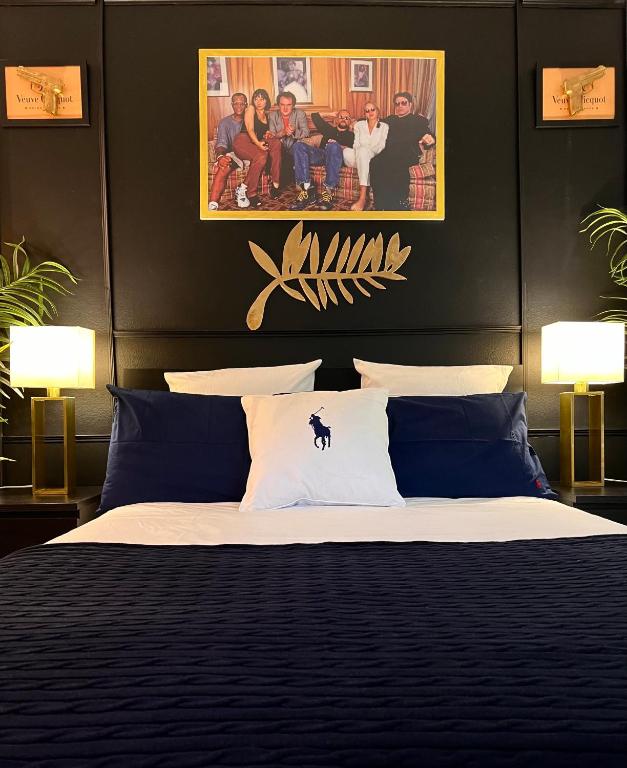 une chambre avec un grand lit avec des oreillers bleus dans l'établissement Palais 5min Luxury&Cinema Studio, à Cannes