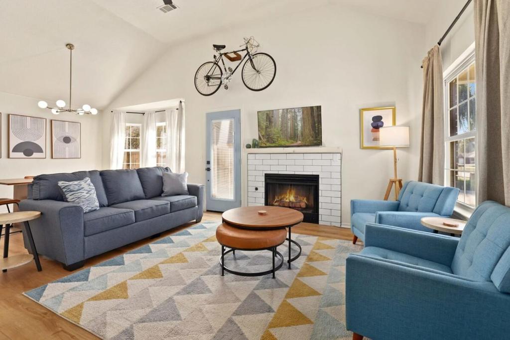 uma sala de estar com sofás azuis e uma bicicleta na parede em Easy E-0 3 MI Walk to DT & Momentary em Bentonville