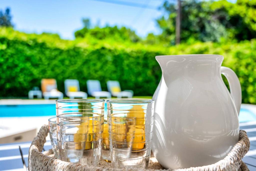 a white vase and some glasses on a table at Sophia's Pool Oasis in Los Angeles