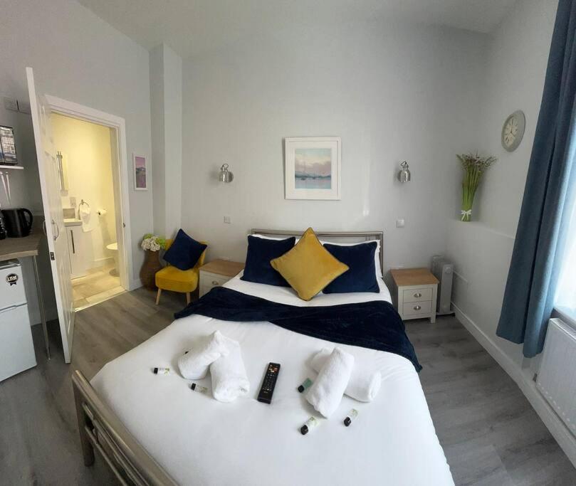 una camera da letto con un letto bianco con cuscini blu e gialli di The Niche a York