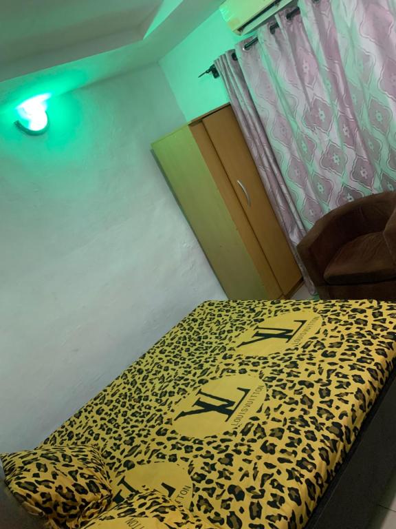 Una habitación con una mesa de leopardo y una cama en CLASSIC SUITES ANNEX en Ilorin