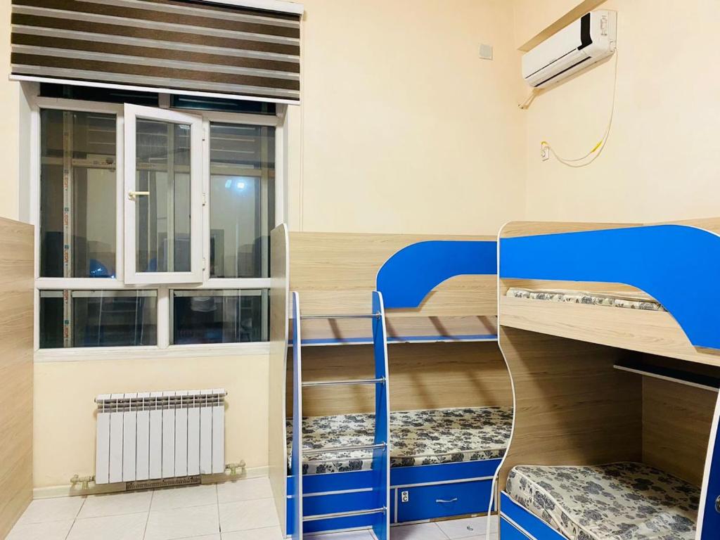 Zimmer mit 2 Etagenbetten und einem Fenster in der Unterkunft Sakhohostel in Karategin