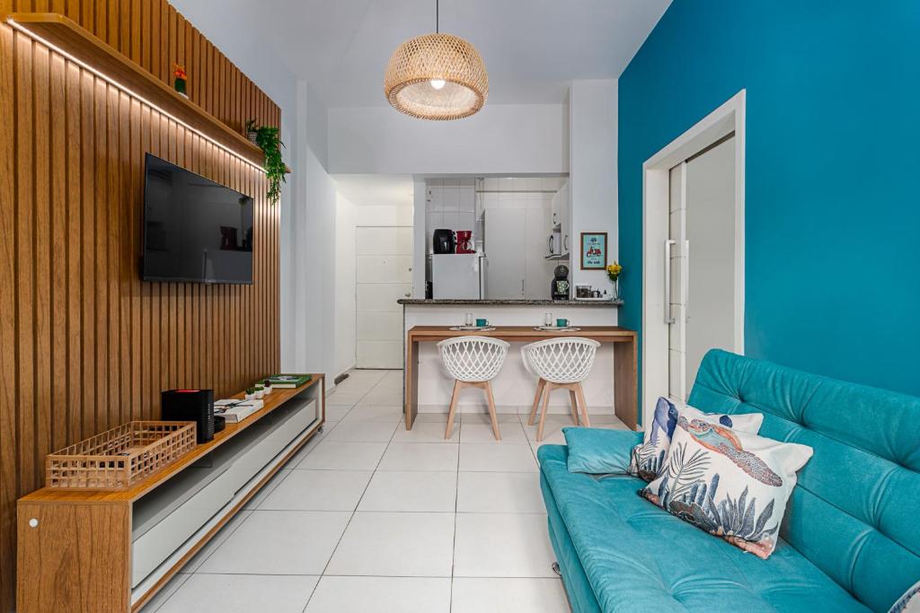 sala de estar con sofá azul y cocina en Modern Copacabana Apartment, en Río de Janeiro