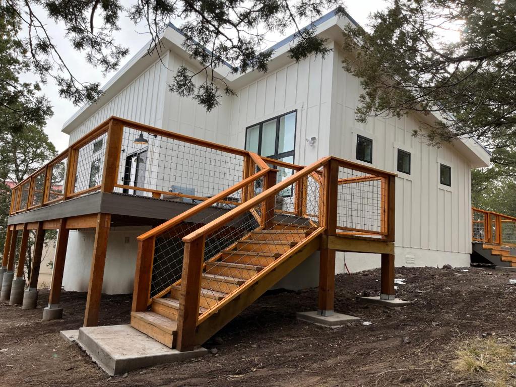 a house with a wooden staircase in front of it at Thunder Hollow in Ruidoso