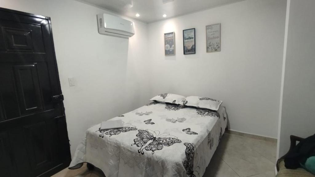 a bedroom with a bed in a white room at El Hogar de Ami in Cali