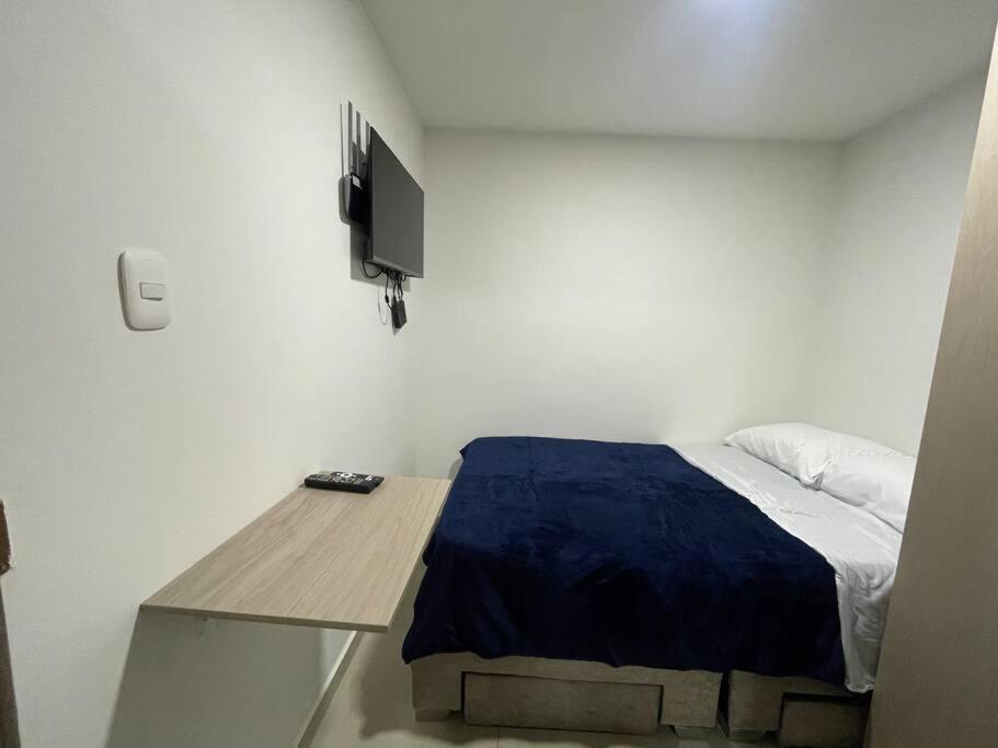 - une chambre avec un lit et un bureau avec une télévision dans l'établissement Apartaloft en el centro 205, à Pereira