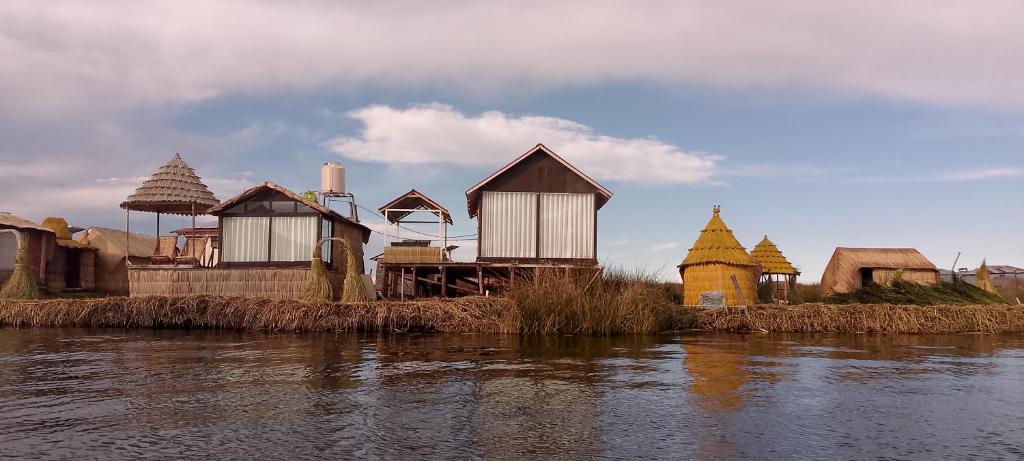 un grupo de casas en una isla en el agua en Coila Titicaca lodge, en Puno