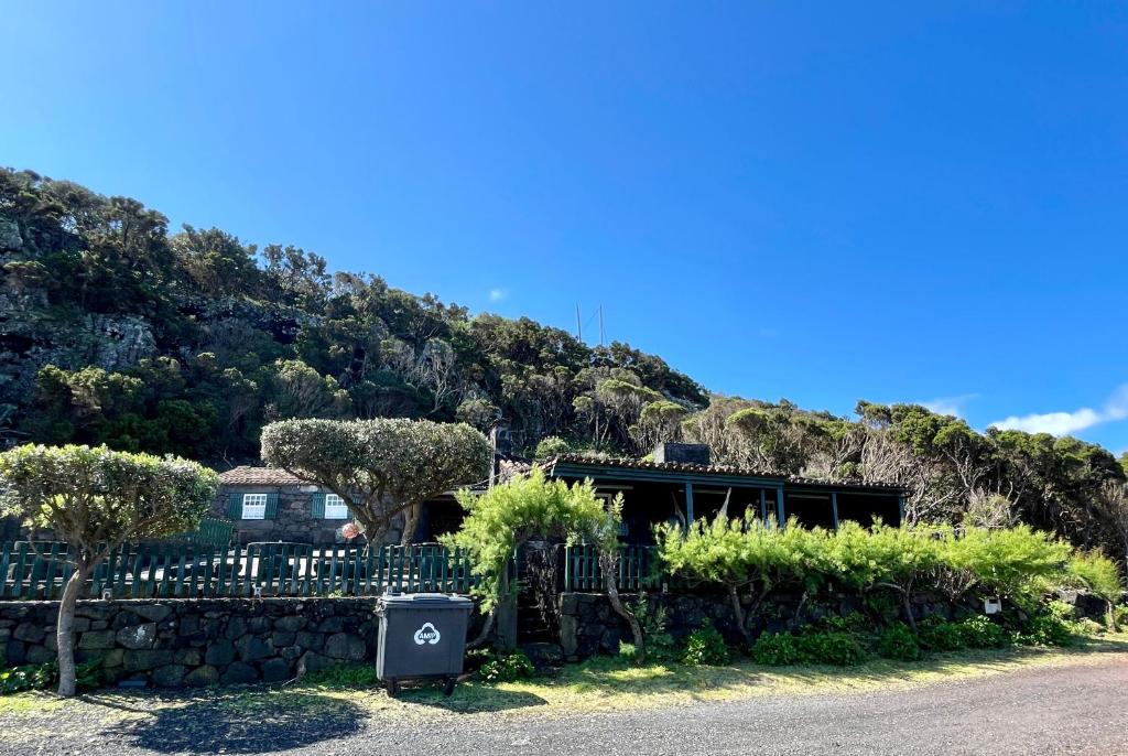 una casa di fronte a una collina con una recinzione di Casa do Carregadouro a São Roque do Pico