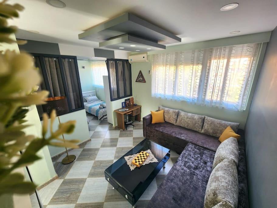 ein Wohnzimmer mit einem Sofa und einem Tisch in der Unterkunft Appartement cosy tout équipé centre-ville, Tlemcen in Tlemcen